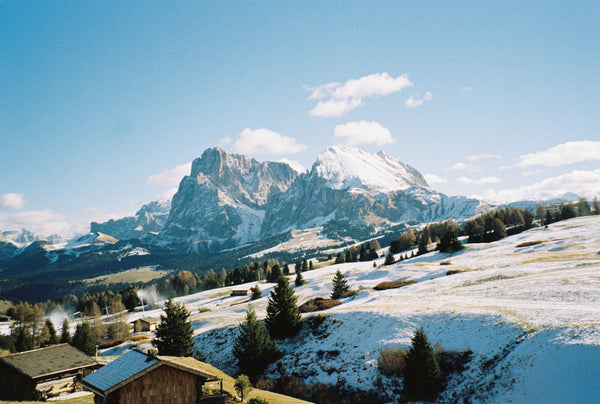 Analog photo print on Fujifilm paper featuring Sasso Lungo in the Dolomites on a clear winter day, with snow-covered peaks glowing under the bright sun and crisp blue skies above.