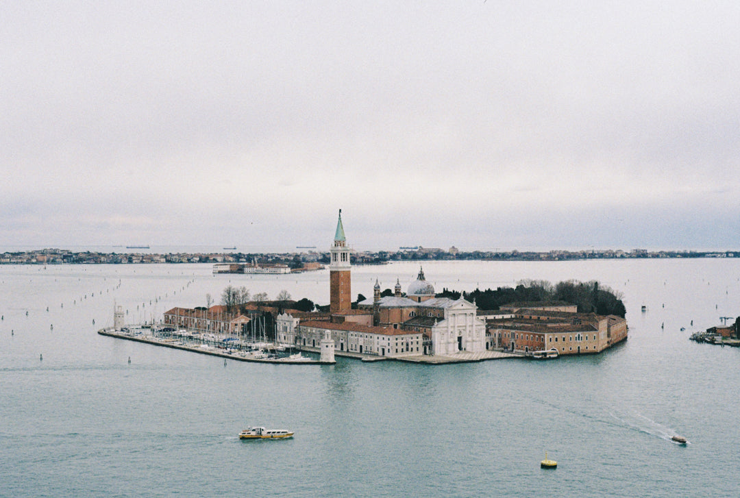 Analog photo print on Fujifilm paper featuring a view of Venice from the Loggetta del Sansovino, with the San Giorgio Maggiore Church standing out against the island. Boats float across the lagoon, and the cool winter light adds to the tranquil scene.